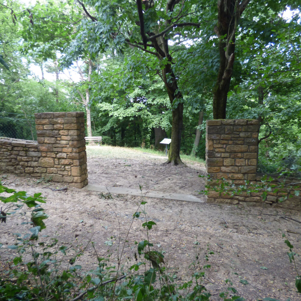 Un chemin de randonnées entre une ancienne construction au milieu de la forêt.