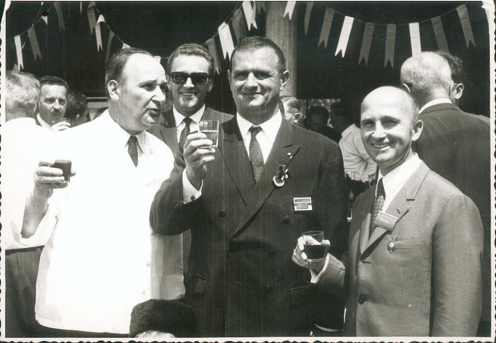 Une photo en noir et blanc de 3 hommes en costard qui pose pour la photo. Nous pouvons retrouver Monsieur Jean-Pierre Haeberlin et Monsieur Paul Bocuse.