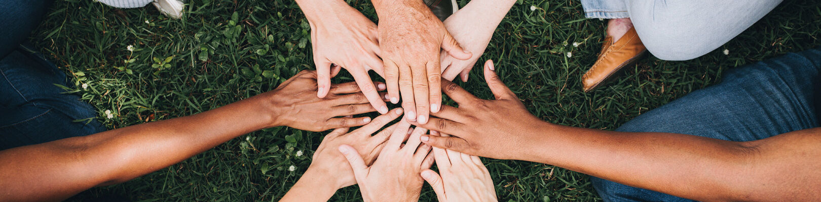Des personnes tendent les mains pour se motiver avant de commencer la vie associative.
