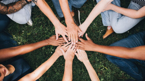 Des personnes tendent les mains pour se motiver avant de commencer la vie associative.