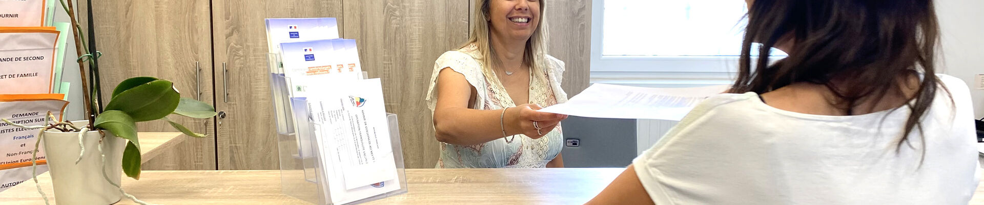 Une femme se présente à l'accueil de la maire de Collonges au Mont d'Or pour refaire un document de son état civil.