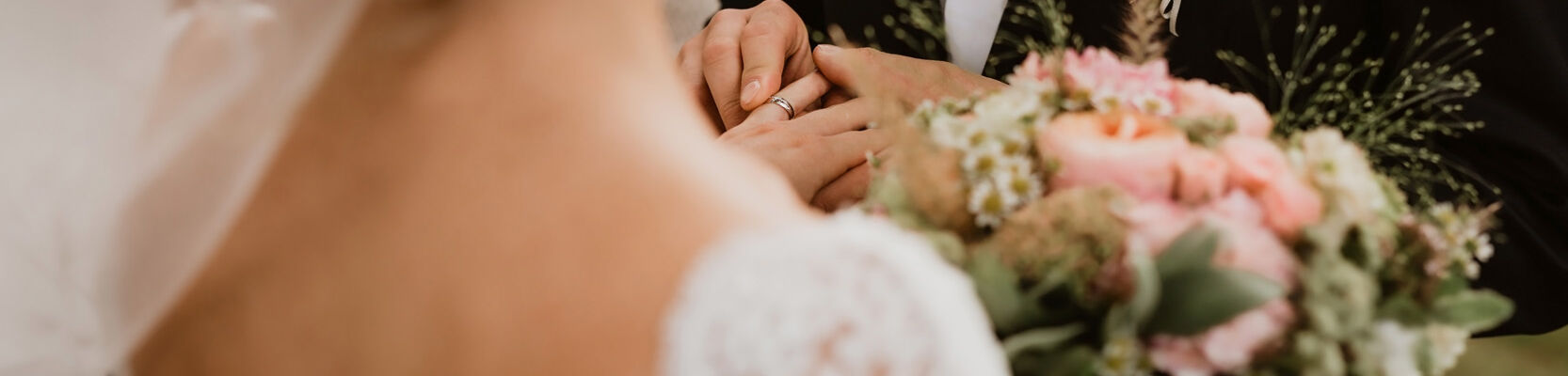 Pendant un mariage , une mariée porte un bouquet de fleur dans ses mains et le présente à son futur marie.