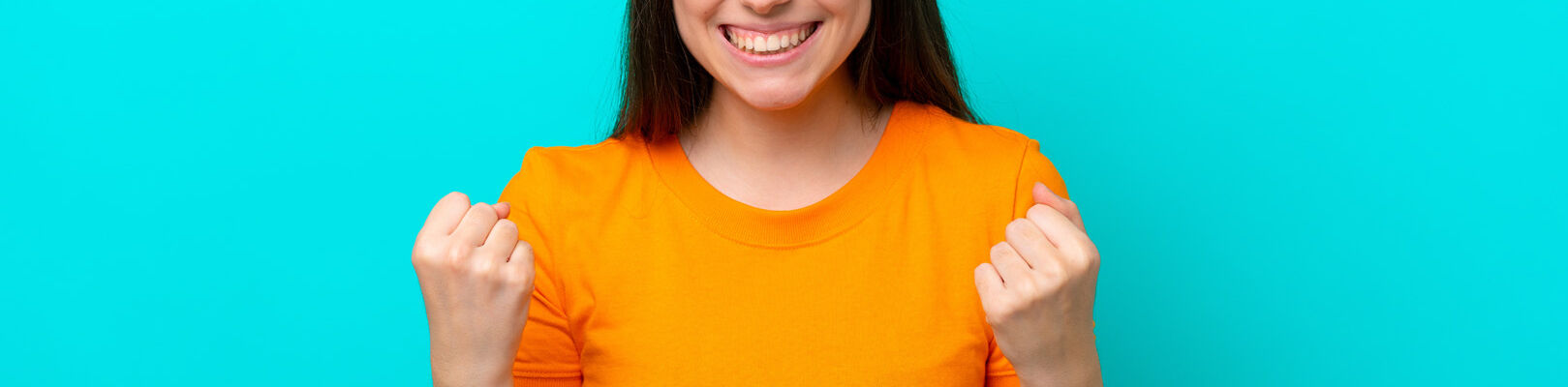Une femme avec un teeshirt orange sert les points en souriant.