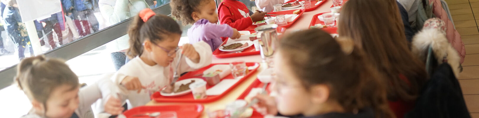 Les enfants de l'école scolaire mangent grâce à la restauration scolaire de l'école.