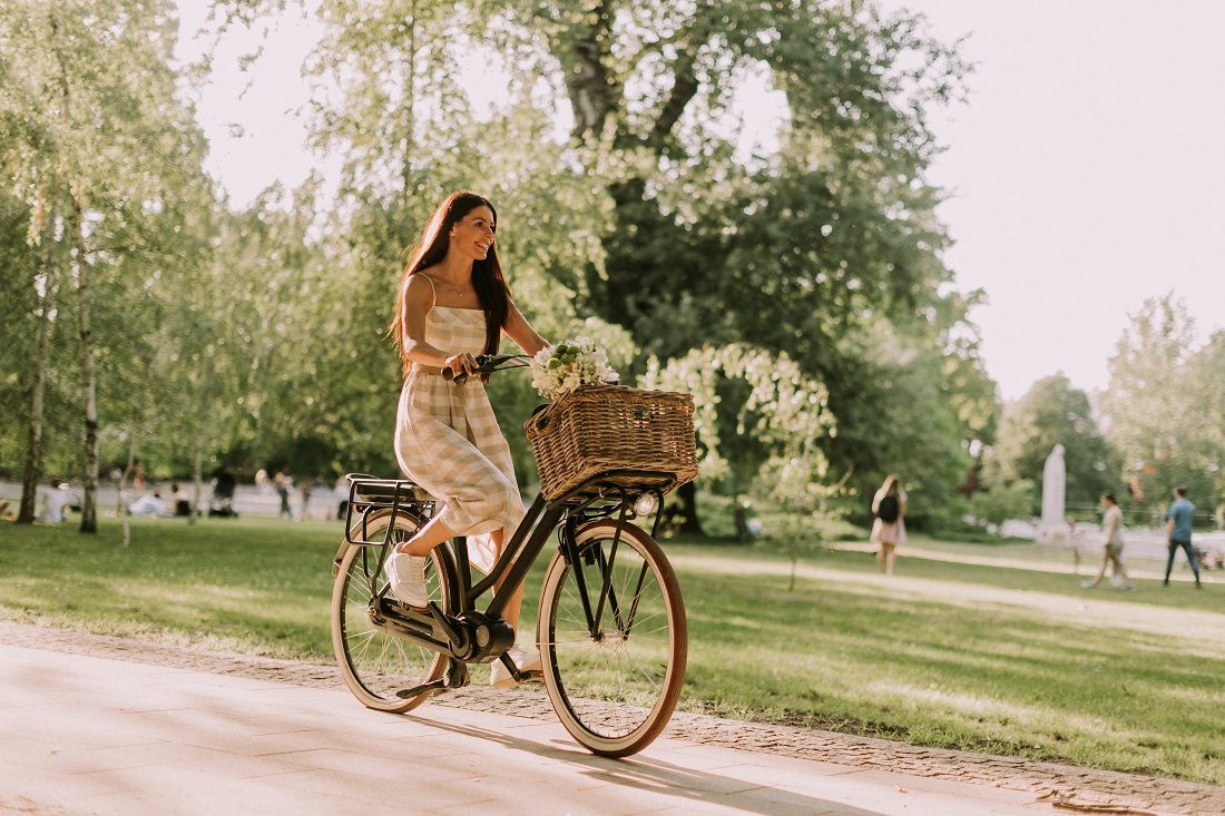 Jeune femme sur un vélo dans un parc