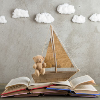 un voilier miniature navigure sur un livre ouvert dans un esprit poétique