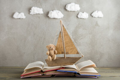 un voilier miniature navigure sur un livre ouvert dans un esprit poétique