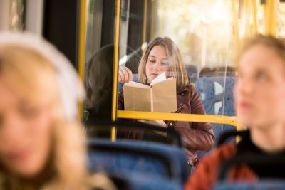 une personne lit un livre dans un bus